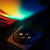 A smartwatch resting on a surface washed in rainbow light
