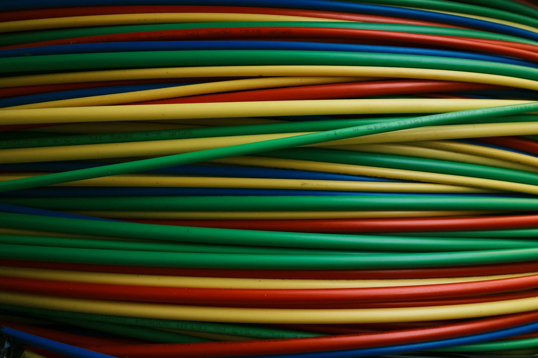 A tight bundle of brightly coloured cables running side by side